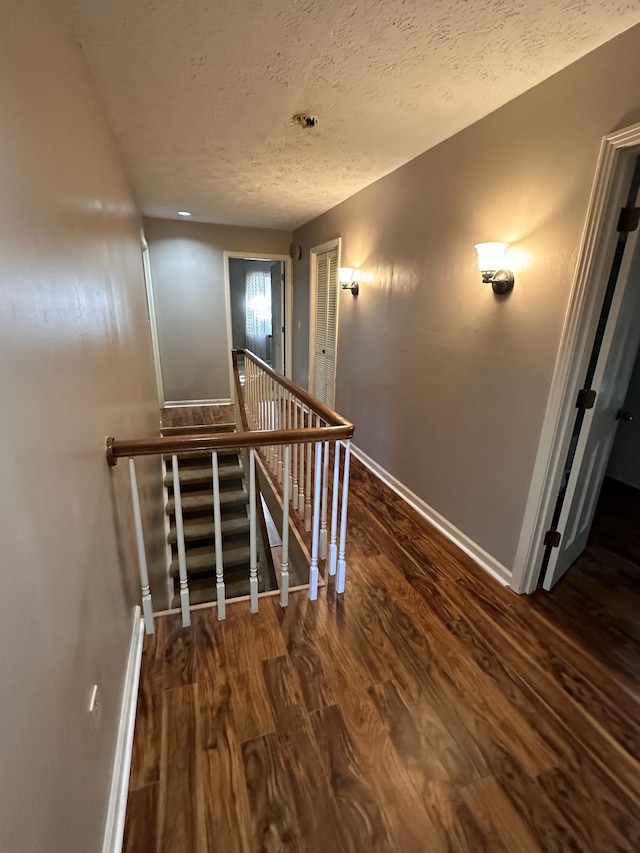 stairway featuring hardwood / wood-style floors and a textured ceiling