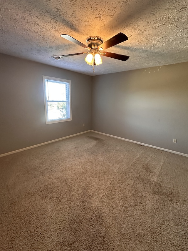 spare room featuring ceiling fan, a textured ceiling, and carpet flooring