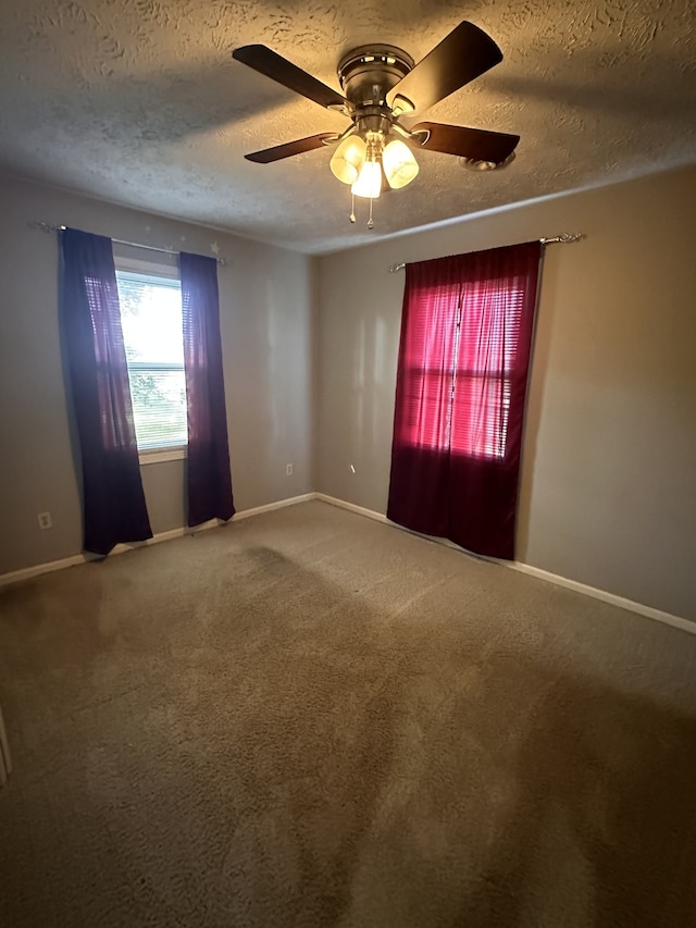 empty room with carpet floors, a textured ceiling, and ceiling fan