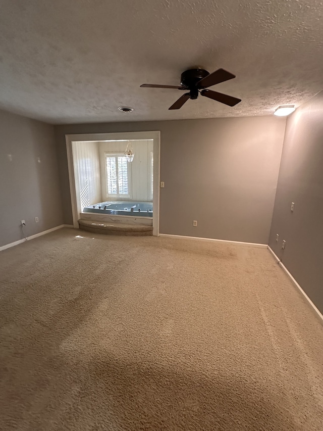 empty room with carpet, a textured ceiling, and ceiling fan