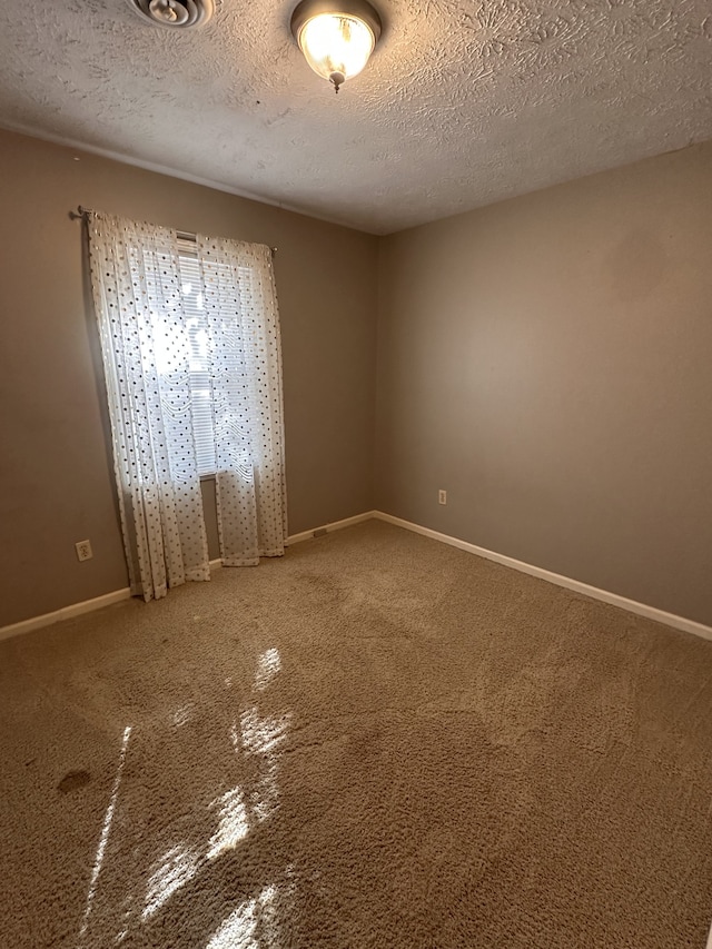 empty room featuring carpet flooring and a textured ceiling