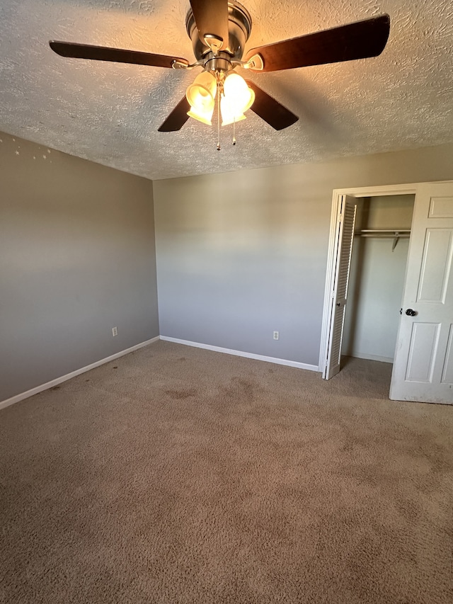 unfurnished bedroom with ceiling fan, a textured ceiling, a closet, and carpet floors