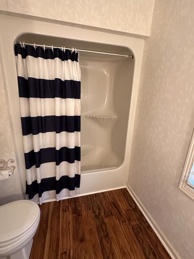 bathroom featuring wood-type flooring, toilet, and shower / tub combo with curtain