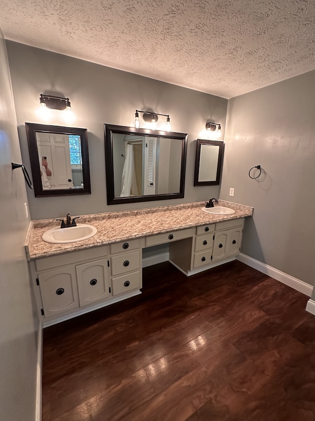 bathroom featuring hardwood / wood-style flooring, vanity, and a textured ceiling