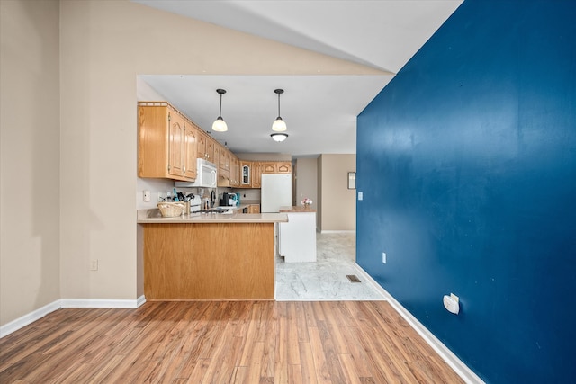 kitchen with lofted ceiling, kitchen peninsula, light hardwood / wood-style flooring, and white appliances