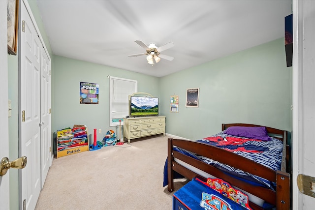 bedroom featuring light carpet, ceiling fan, and a closet