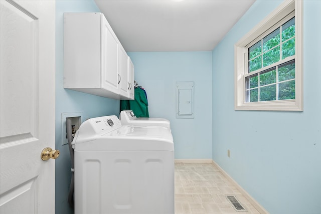 laundry room featuring cabinets, separate washer and dryer, light tile patterned flooring, and electric panel