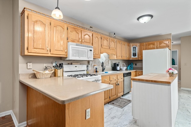 kitchen featuring hanging light fixtures, sink, white appliances, and kitchen peninsula