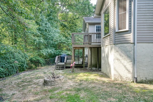 view of yard featuring a wooden deck and a fire pit