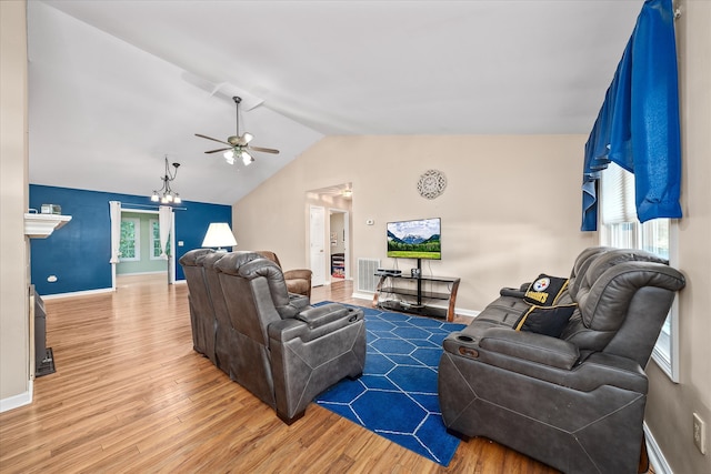 living room featuring ceiling fan with notable chandelier, hardwood / wood-style flooring, and lofted ceiling