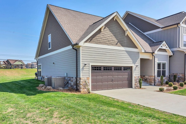 craftsman house featuring a garage, a front yard, and central air condition unit