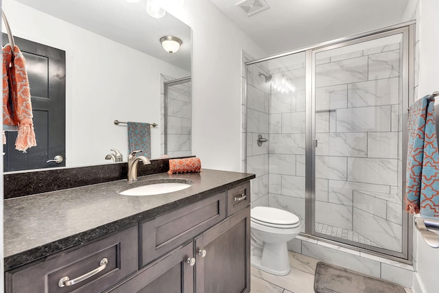 bathroom featuring vanity, toilet, and a shower with door