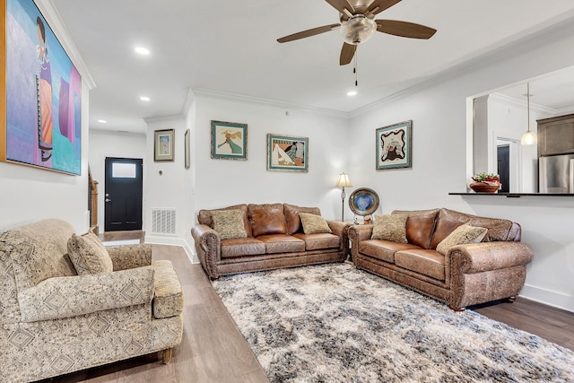 living room with hardwood / wood-style floors, ornamental molding, and ceiling fan