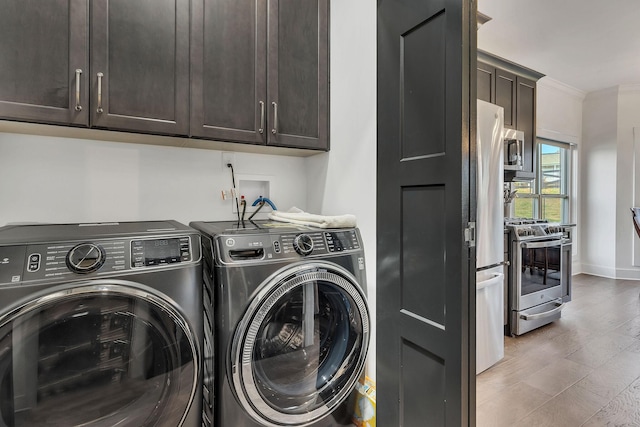 laundry area with dark hardwood / wood-style flooring, cabinets, ornamental molding, and washer and dryer