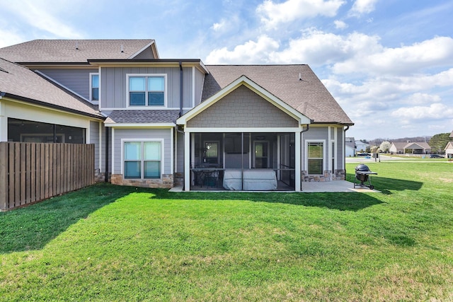 rear view of property featuring a sunroom, a lawn, and a patio area