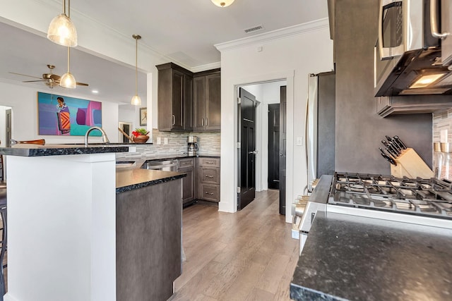 kitchen with sink, pendant lighting, dark brown cabinetry, and kitchen peninsula