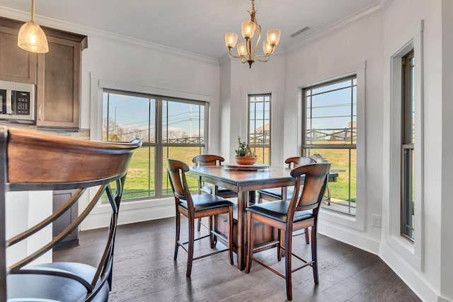 dining room featuring ornamental molding, dark hardwood / wood-style floors, and a chandelier