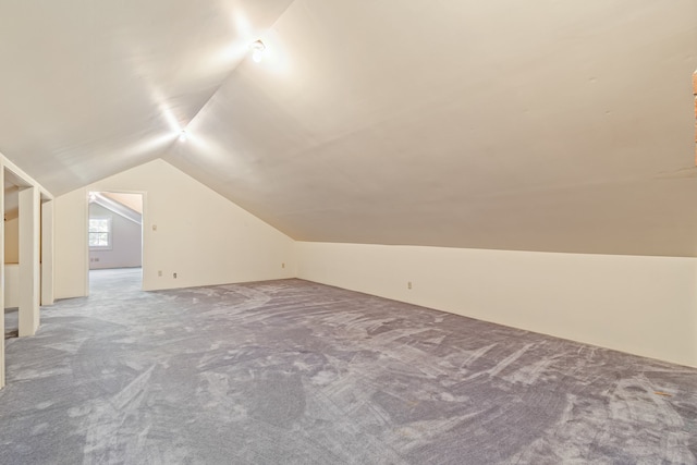 bonus room with vaulted ceiling and carpet