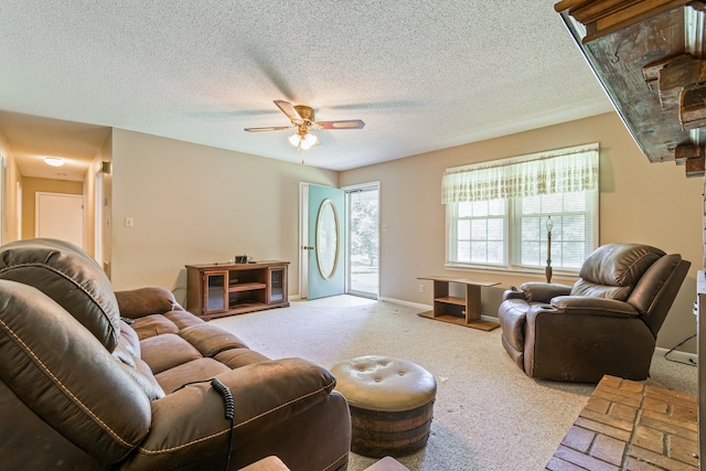 living room with a textured ceiling, light colored carpet, and ceiling fan