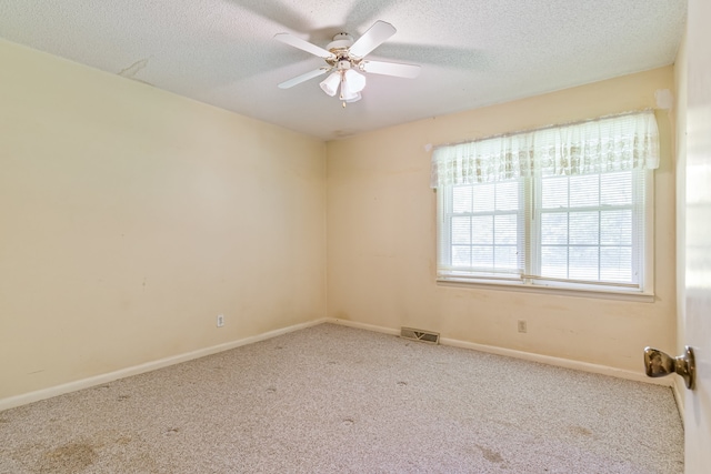 empty room with light colored carpet, a textured ceiling, and ceiling fan