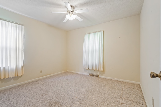 empty room featuring light carpet, a textured ceiling, and ceiling fan