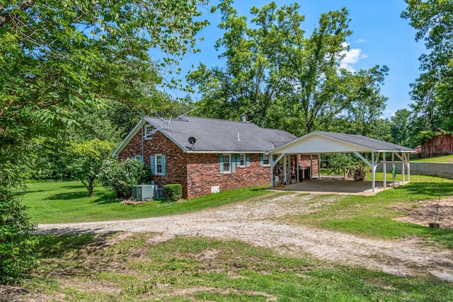 rear view of property with a carport and a yard