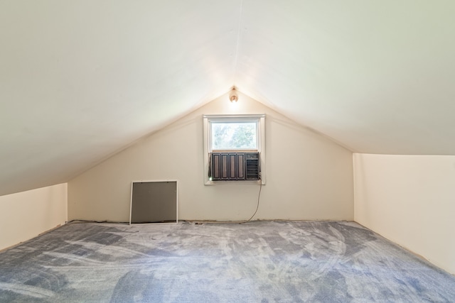 additional living space with cooling unit, lofted ceiling, and carpet flooring