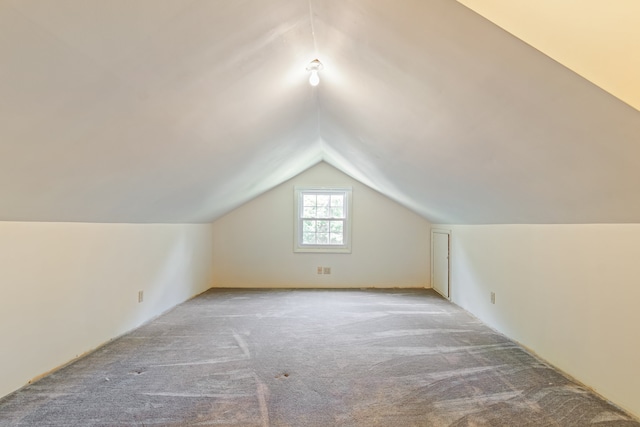 bonus room with carpet flooring and vaulted ceiling