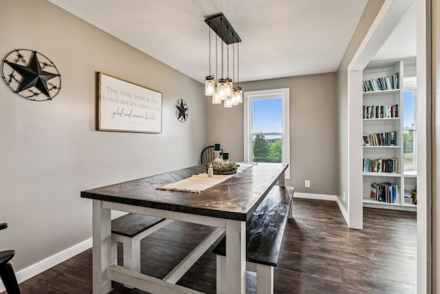 dining space with an inviting chandelier, dark hardwood / wood-style floors, and built in shelves