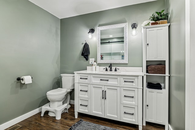 bathroom featuring vanity, toilet, and hardwood / wood-style floors