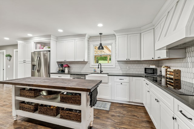 kitchen featuring stainless steel appliances, sink, pendant lighting, backsplash, and dark hardwood / wood-style floors