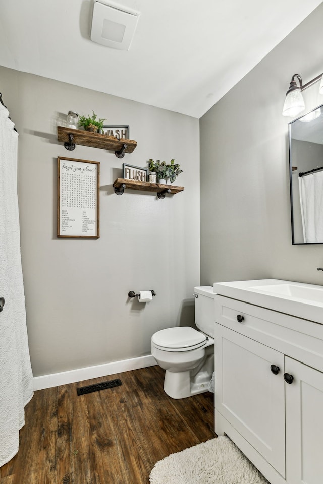 bathroom featuring toilet, hardwood / wood-style floors, and vanity