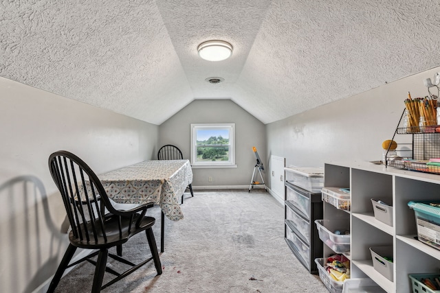 interior space with a textured ceiling, light colored carpet, and lofted ceiling