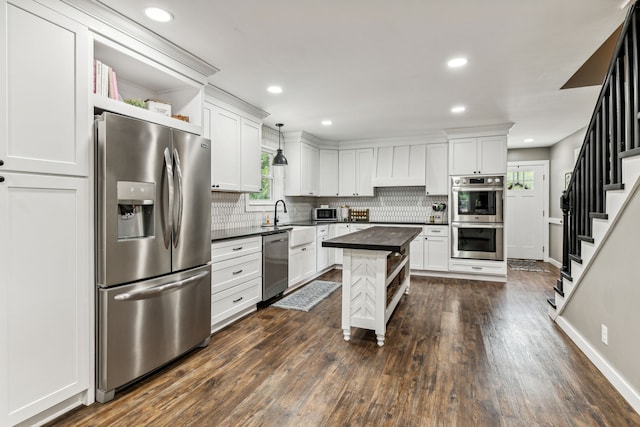 kitchen featuring a center island, appliances with stainless steel finishes, pendant lighting, and dark hardwood / wood-style flooring