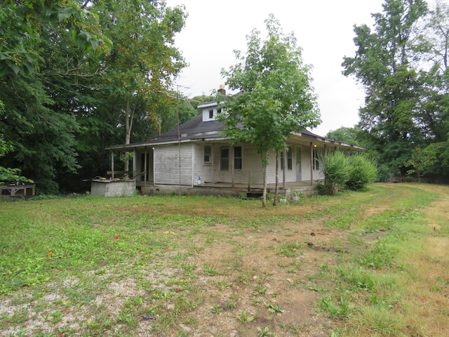 back of property featuring a yard