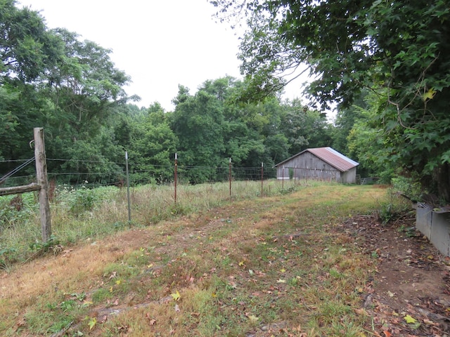 view of yard featuring fence and an outbuilding