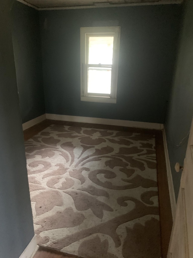 empty room featuring carpet and baseboards