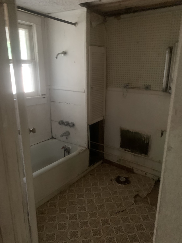 bathroom with washtub / shower combination and tile patterned floors