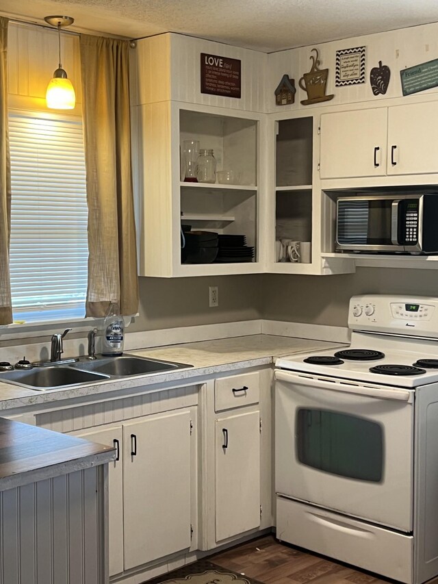 kitchen with white cabinetry, white range with electric stovetop, and decorative light fixtures