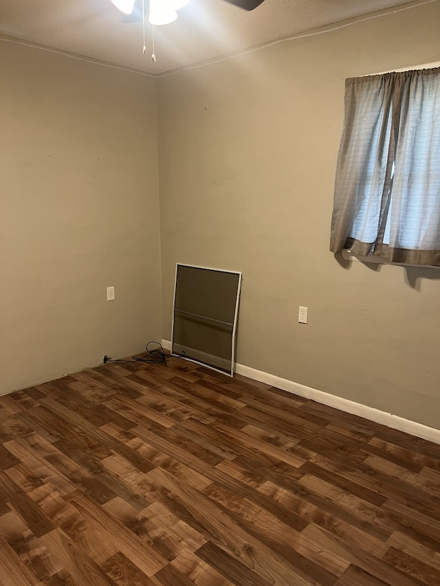 spare room with dark hardwood / wood-style flooring and ceiling fan