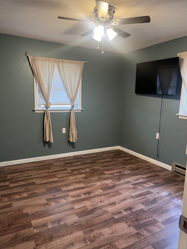 spare room featuring ceiling fan, a textured ceiling, hardwood / wood-style flooring, and a baseboard heating unit