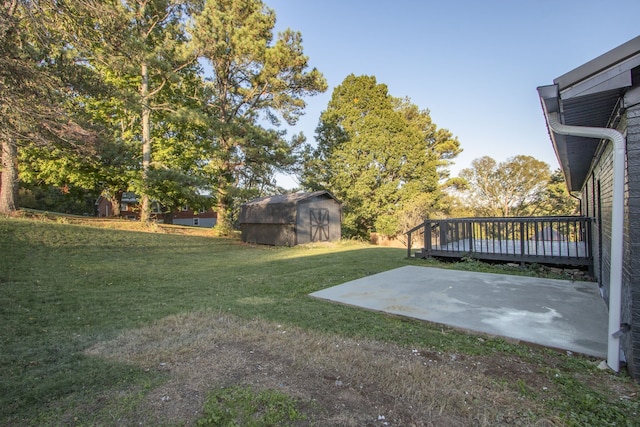 view of yard with a wooden deck, a shed, and a patio area