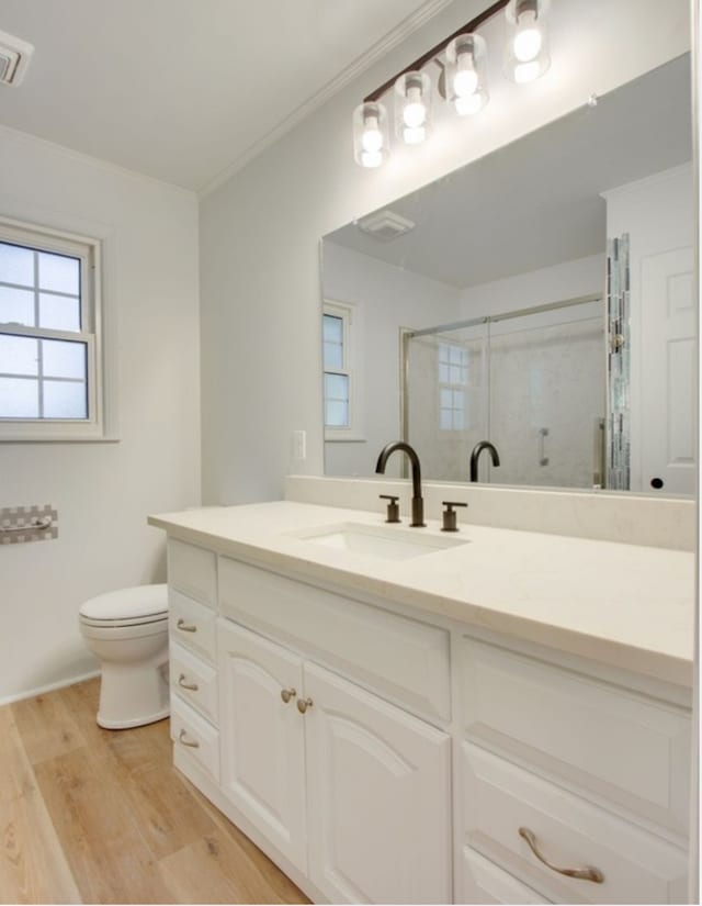 bathroom featuring vanity, toilet, ornamental molding, an enclosed shower, and hardwood / wood-style floors