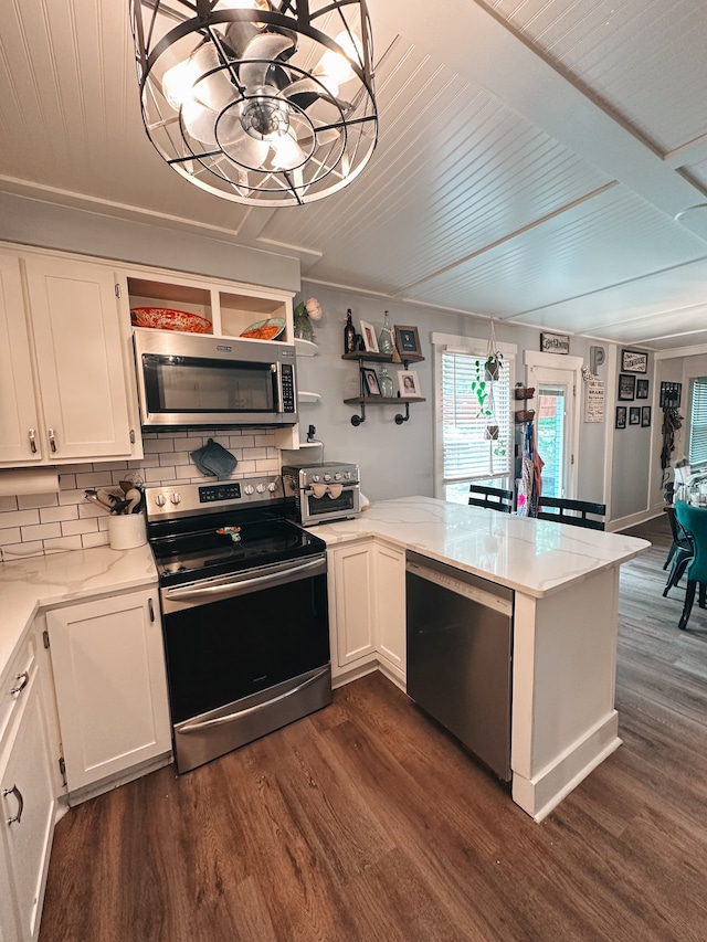 kitchen featuring dark hardwood / wood-style flooring, light stone countertops, white cabinets, and stainless steel appliances