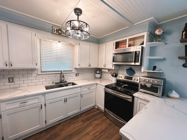 kitchen featuring appliances with stainless steel finishes, sink, pendant lighting, dark hardwood / wood-style floors, and white cabinetry