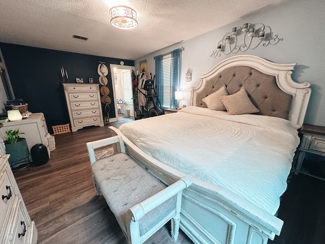 bedroom with a textured ceiling and dark hardwood / wood-style flooring