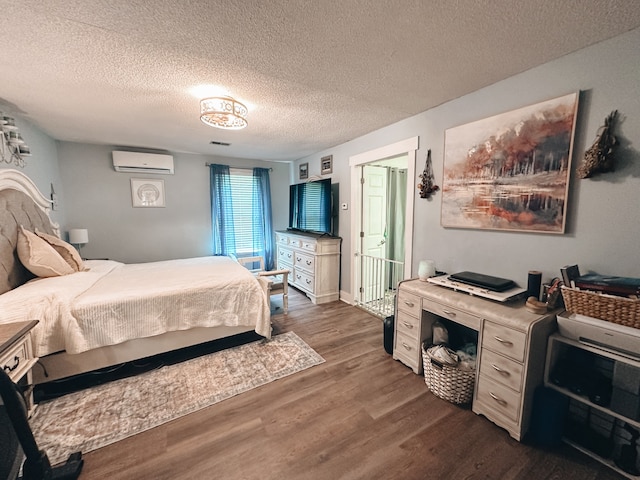 bedroom featuring an AC wall unit, dark hardwood / wood-style flooring, and a textured ceiling