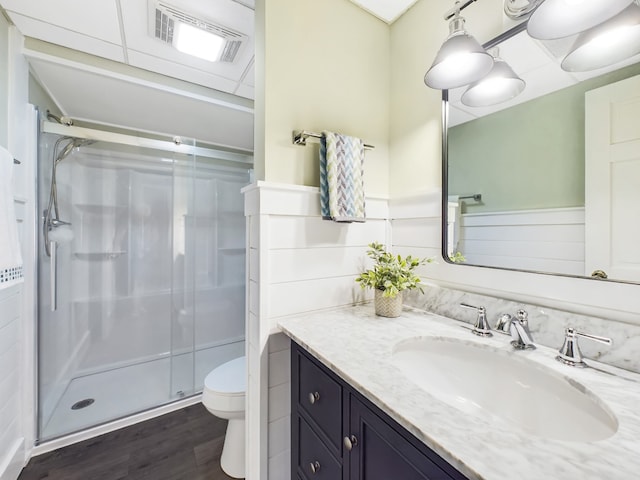 bathroom with vanity, toilet, walk in shower, and hardwood / wood-style floors