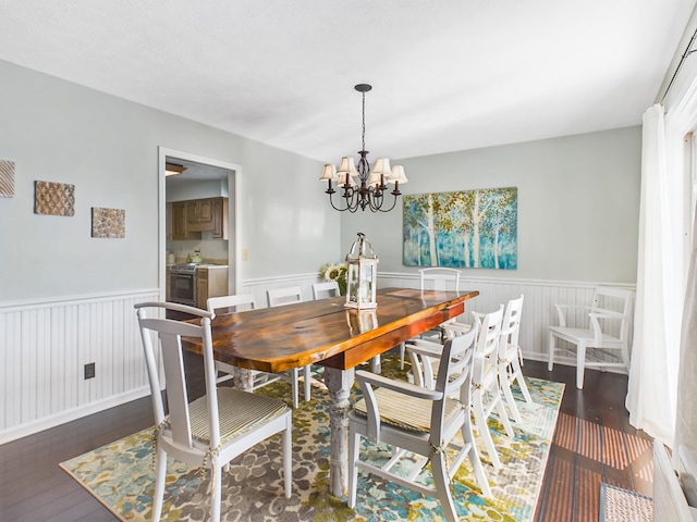 dining room with dark hardwood / wood-style flooring and a notable chandelier