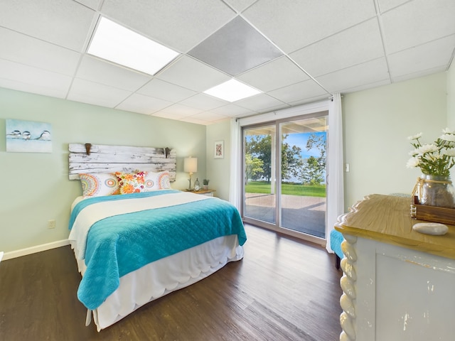 bedroom featuring a drop ceiling, access to outside, and hardwood / wood-style floors